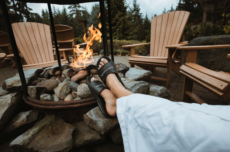 Person relaxing by a firepit at Scandinave Spa in Whistler. Spa retreats Vancouver. 
