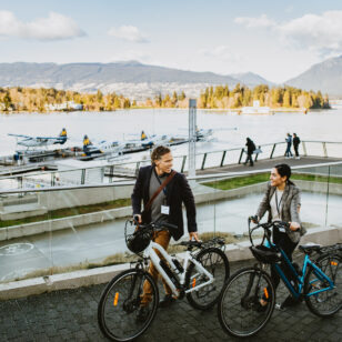 Two people e-biking on the Coal Harbour Seawall in Vancouver