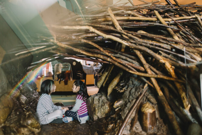 Children inside a replica beaver lodge at the Search: Sara Stern Gallery at Science World