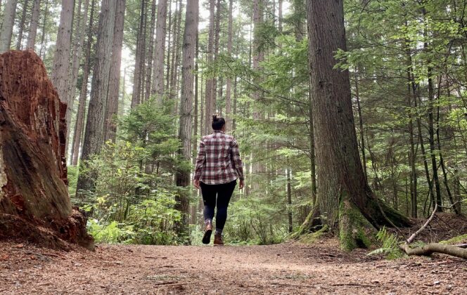 A woman walks along a trail in Pacific Spirit Regional Park in Vancouver