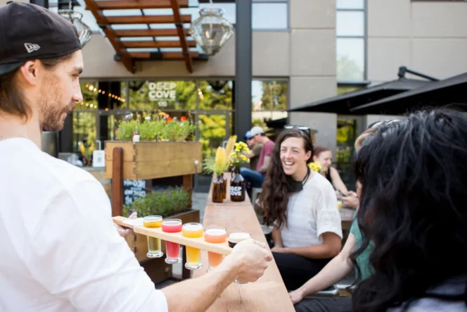 A server brings beer to the patio at Deep Cove Brewers in North Vancouver