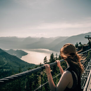 A woman enjoys the view from the Sky Pilot Suspension Bridge at the Sea to Sky Gondola near Vancouver