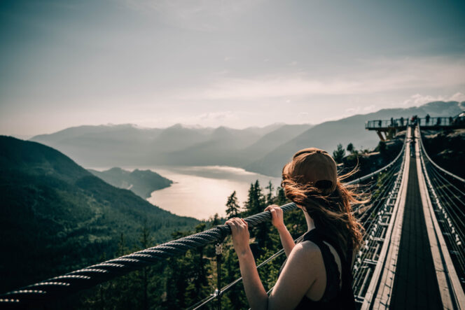 A woman enjoys the view from the Sky Pilot Suspension Bridge at the Sea to Sky Gondola near Vancouver