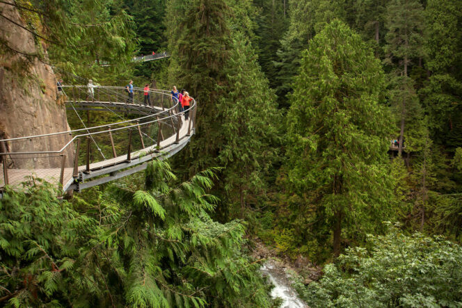 People walk on a suspended walkway at the Cliffwalk at Capilano Suspension Bridge in North Vancouver