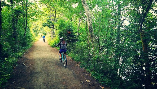 Cyclists on a forest trail at Elk and Beaver Lakes on southern Vancouver Island