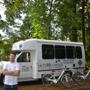 Paul Taplin of Into the Wild Cycling Tours poses in front of his tour bus and bikes