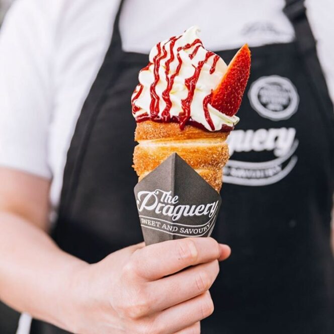 A worker holds an ice-cream filled chimney cone from The Praguery food truck