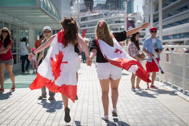 Two women wear Canadian flags at Canada Day celebrations in Vancouver