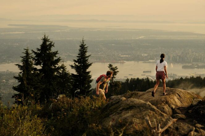 A couple hiking to a rock bluff viewpoint on Grouse Mountain