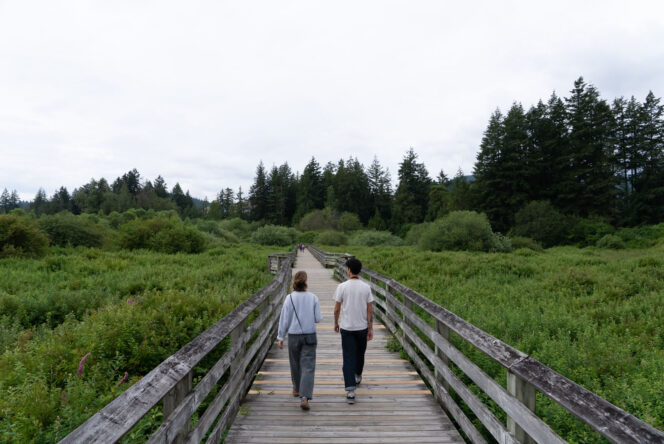 Two people walk along a boardwalk at Langford Lake