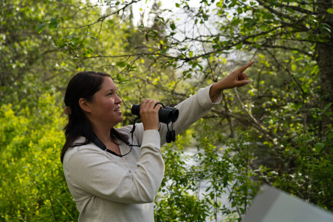 A woman birdwatching at Green Lake in Whistler