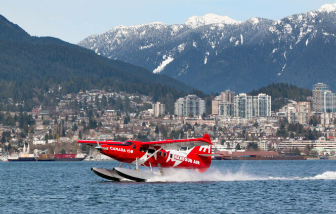 A floatplane taking off in front of snowy mountains in Vancouver