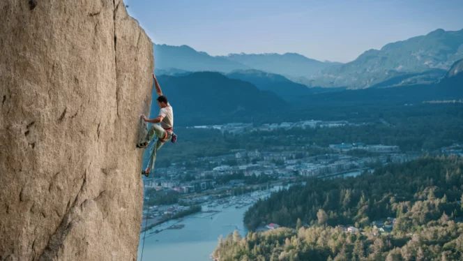 Promotional image of a rock climber high above a snowy valley for the 2024 Vancouver International Mountain Film Festival