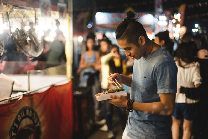 A man eats street food at the Richmond Night Market